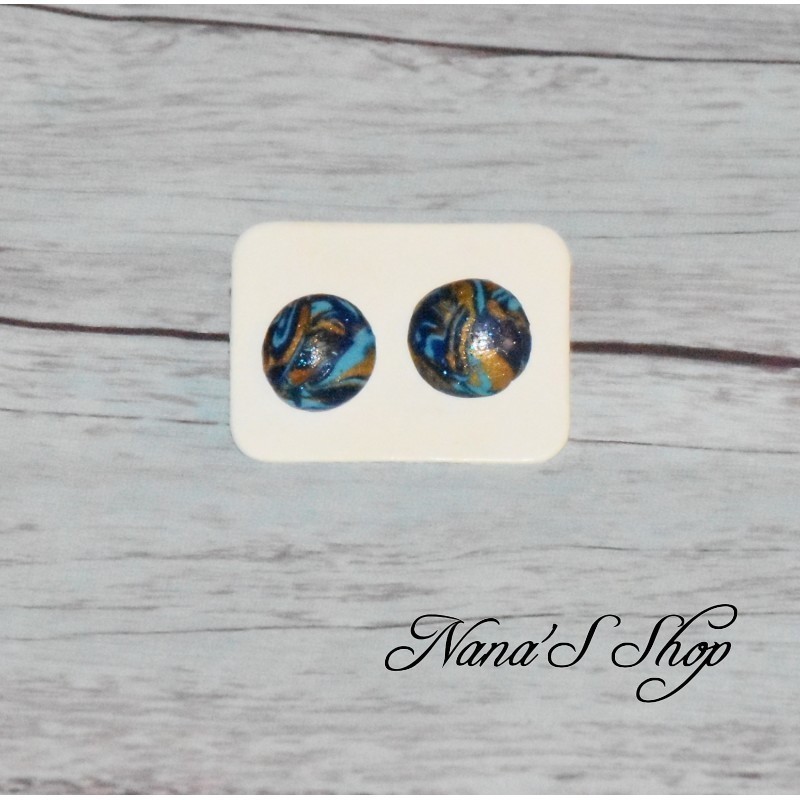 Boucles d'oreilles clous fantaisie, coloré et doré, en pâte polymère, forme rond, coloris bleu foncé. Boucles d'oreilles clous fantaisie, coloré et doré, en pâte polymère, forme rond, coloris bleu foncé.