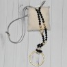 Sautoir en perles fantaisie noires et pendentif grand cercle en métal doré, de la marque Nina Kaufmann.