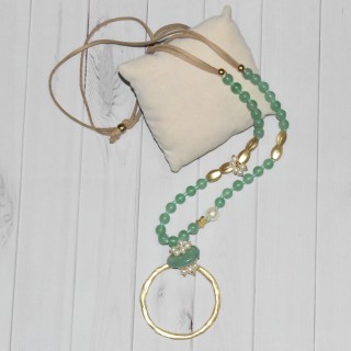 Sautoir en perles fantaisie vertes et pendentif grand cercle en métal doré, de la marque Nina Kaufmann.