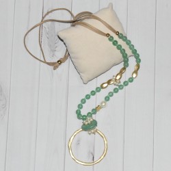 Sautoir en perles fantaisie vertes et pendentif grand cercle en métal doré, de la marque Nina Kaufmann.