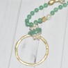 Sautoir en perles fantaisie vertes et pendentif grand cercle en métal doré, de la marque Nina Kaufmann.