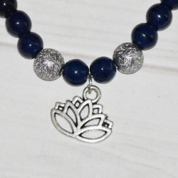 Bracelet élastique, en perles de verre teinté bleu foncé et fleur de Lotus en métal argenté, détail.