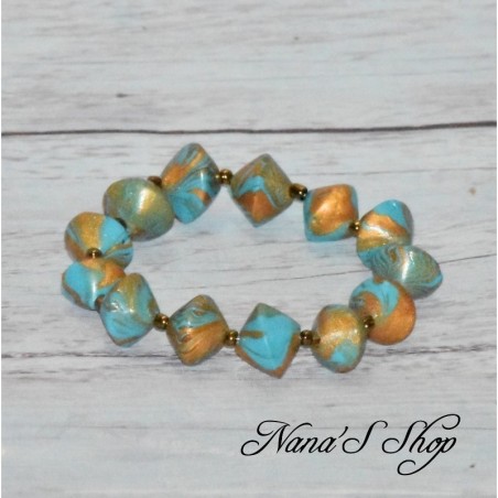 Bracelet élastique, perles colorées et dorées, coloris bleu turquoise. Bracelet élastique, perles colorées et dorées, coloris bleu turquoise.